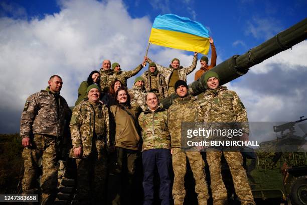 Britain's Defence Secretary Ben Wallace poses in front of a FV 4034 Challenger 2 tank with Ukrainian soldiers who are undergoing training at...