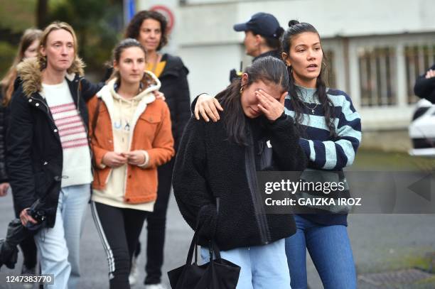 Mourners walk as students and their parents leave after gathering at Saint-Thomas dAquin middle school, where a teacher died after being stabbed by a...