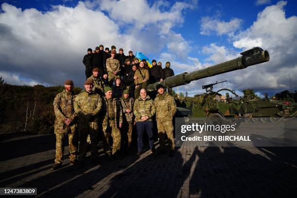 Britain's Defence Secretary Ben Wallace poses in front of a FV 4034 Challenger 2 tank with Ukrainian soldiers who are undergoing training at...