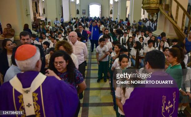 Adalberto Benitez , the first Paraguayan Cardinal, and a priest give the communion to people attending mass during the Catholic celebration of Ash...
