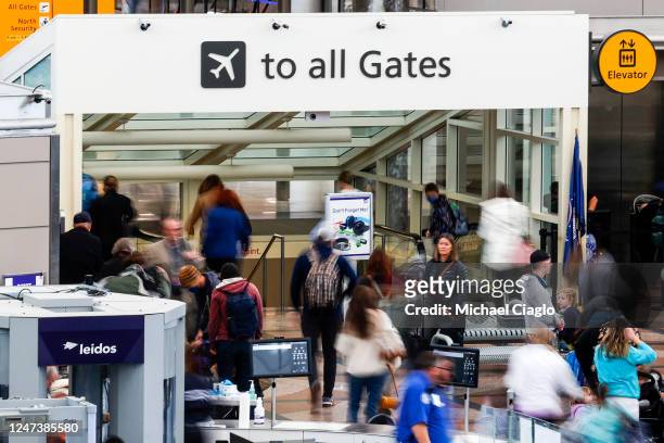 Travelers head toward their gates after passing through a TSA security checkpoint during a winter storm at Denver International Airport on February...