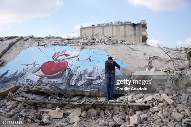 Syrian graffiti artists Aziz Asmar, Salam Hamid and Muhammad Enis Hamdun paint the struggle of the earthquakes on the rubble of a collapsed building...