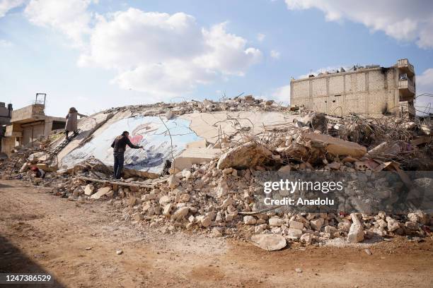 Syrian graffiti artists Aziz Asmar, Salam Hamid and Muhammad Enis Hamdun paint the struggle of the earthquakes on the rubble of a collapsed building...