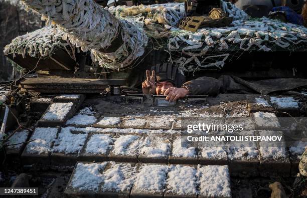 Member of a Ukrainian tank crew gestures a V-sign from his tank in Donetsk region, on February 22 amid Russia's military invasion on Ukraine.