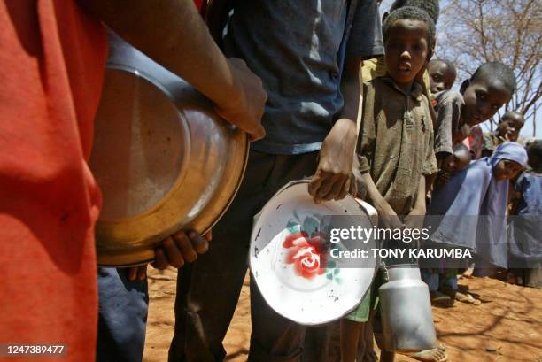 Children queue for relief food at Dambas primarry school, in this 13, February 2006 photo, a meal of maize and dried peas, usually the only one for...