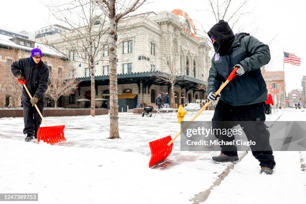 Downtown Denver Business Improvement District employees shovel the sidewalk outside of Union Station during a winter storm on February 22, 2023 in...