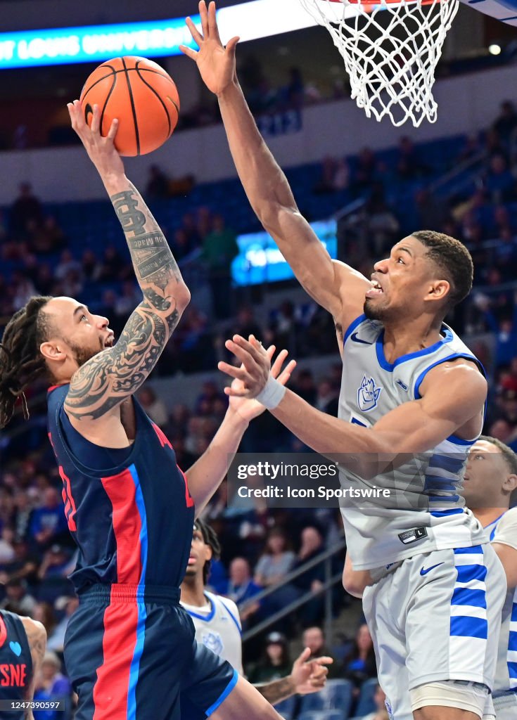 Duquesne forward Joe Reece shoots over Saint Louis University forward ...