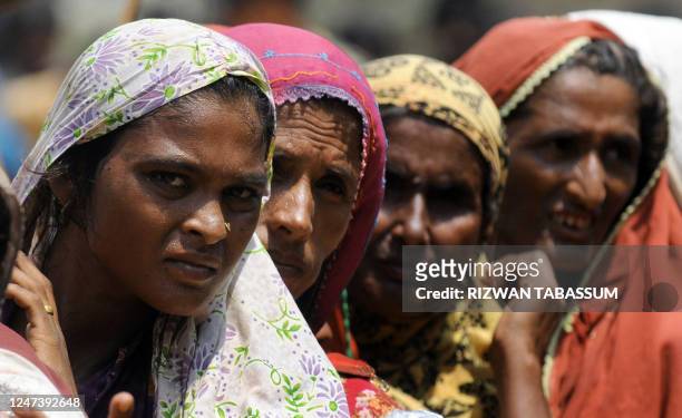 Pakistani women displaced by floods queue for relief goods at a Pakistan's navy distribution point in a makeshift camp in Thatta district on...