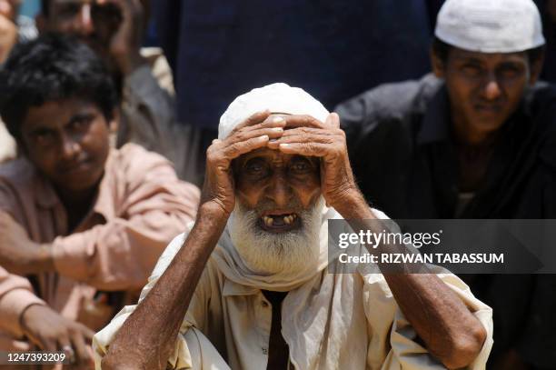Pakistanis displaced by floods wait for relief goods at a Pakistan's navy distribution point in a makeshift camp in Thatta district on September 2,...