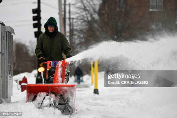 Whittier Elementary School maintenance worker Jim Likely clears snow in front of the closed school as students stayed home for remote learning for...