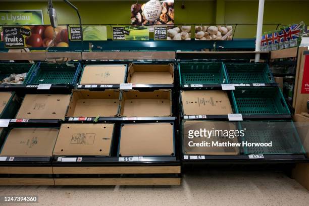 Empty fruit and vegetable shelves in a supermarket on February 22, 2023 in Cardiff, Wales. Aldi, Asda, Morrisons and Tesco have placed limits on the...