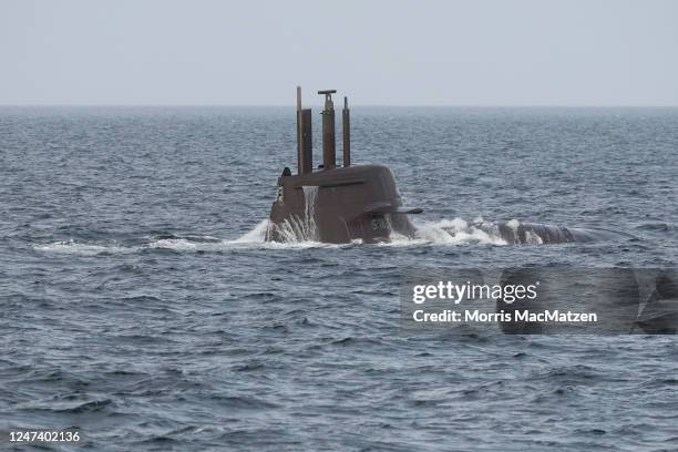 Submarine emerges next to the frigate Hessen during the inaugural visit of German Defence Minister Boris Pistorius to the German Navy on February 21,...