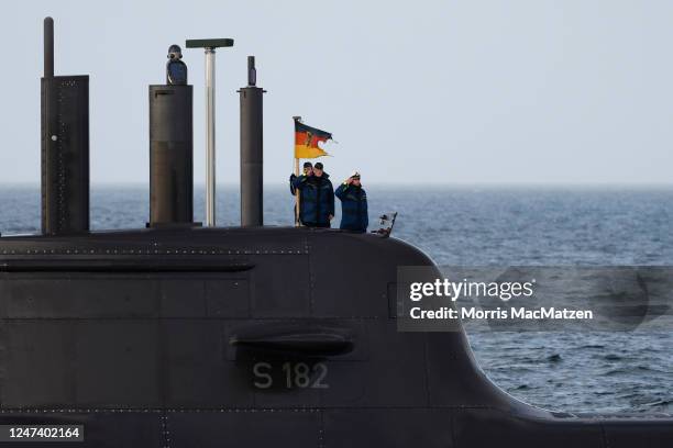 Navy officers on board a submarine salute as they pass the frigate Hessen during the inaugural visit of German Defence Minister Boris Pistorius to...