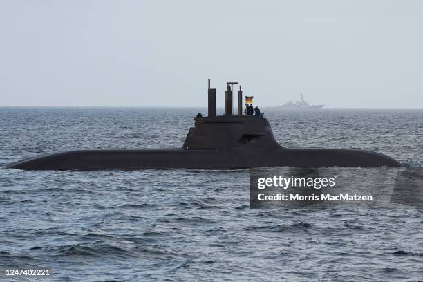 Navy officers on board a submarine salute as they pass the frigate Hessen during the inaugural visit of German Defence Minister Boris Pistorius to...