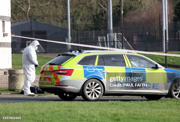 Police forensics officer works at the scene of a shooting of an off duty policeman at the Killyclogher Road sports complex in the northern Irish town...