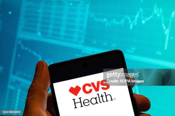 In this photo illustration, the American healthcare company that owns CVS Pharmacy, CVS Health, logo is seen displayed on a smartphone screen with an...
