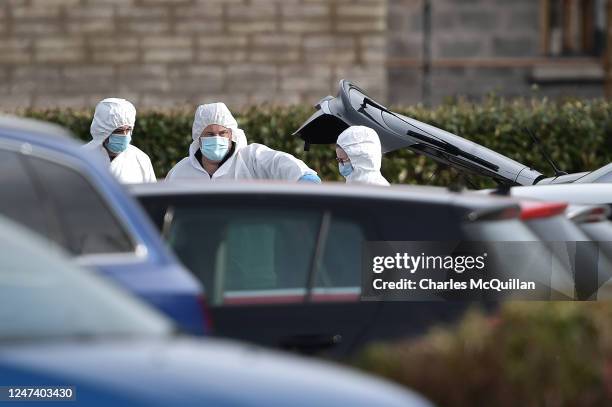 Forensic officers inspect the boot of Detective Chief Inspector John Caldwells car at the scene of last nights shooting at the Youth Sports Centre on...