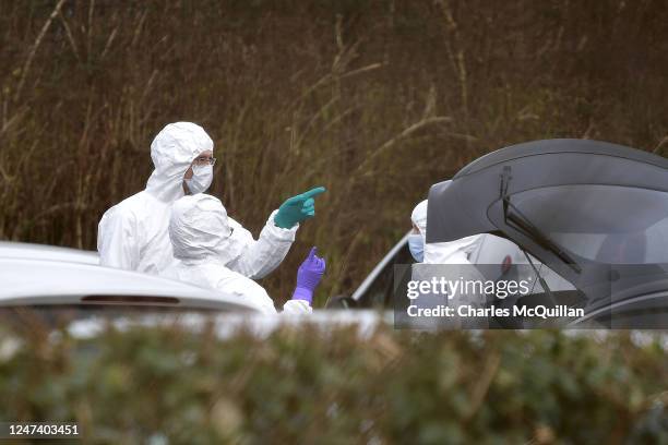 Forensic officers inspect the boot of Detective Chief Inspector John Caldwells car at the scene of last nights shooting at the Youth Sports Centre on...