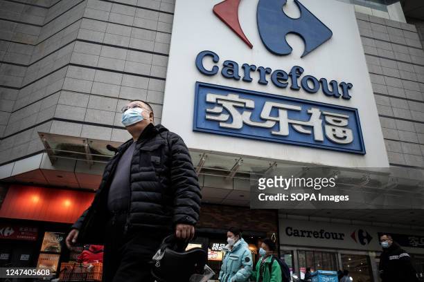 Man walks past a giant signboard of Carrefour store in Wuhan. Carrefour entered the Chinese market in the year 1995 and expanded very quickly,...