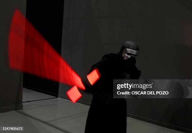 Person dressed as Star Wars saga's character Kylo Ren brandishes his sword on the opening day of the exhibition "Fuenlabrada Friki. Universo Star...