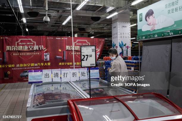 Shopper checks out products in the refrigerator at a Carrefour store in Wuhan. Carrefour entered the Chinese market in the year 1995 and expanded...