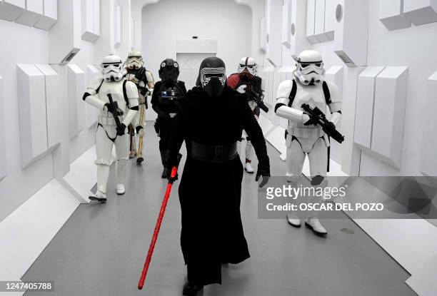 People dressed as Star Wars saga's characters Kylo Ren and Stormtroopers walk along a corridor on the opening day of the exhibition "Fuenlabrada...