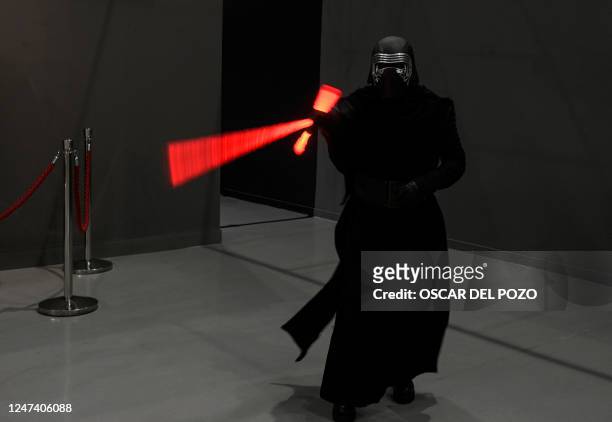 Person dressed as Star Wars saga's character Kylo Ren brandishes his sword on the opening day of the exhibition "Fuenlabrada Friki. Universo Star...