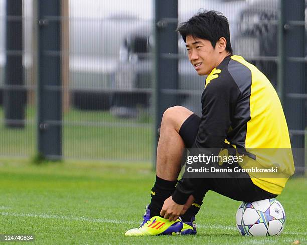 Shinji Kagawa of Dortmund sits on a ball during a training session at the Dortmund Brackel training ground ahead of their UEFA Champions League Group...