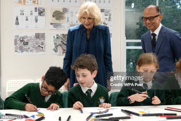 Britain's Camilla, Queen Consort stands with Jimmy Choo as she watches children from a local primary school in a drawing class during a visit to the...