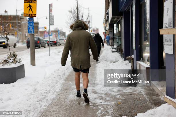 February 23 - A pedestrian in shorts makes their way north along Yonge St. Following a snowstorm that hit Toronto. Lance McMillan/Toronto...