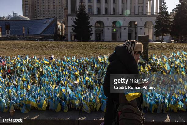 An elderly woman stands next to Ukrainian flags commemorating Ukrainian soldiers killed during the war with Russia, at Independence Square, on...