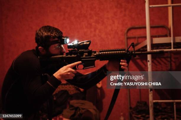 Ukrainian serviceman checks his M4A1 carbine after clening at a base in the Donetsk region on February 23 amid the Russian invasion of Ukraine.