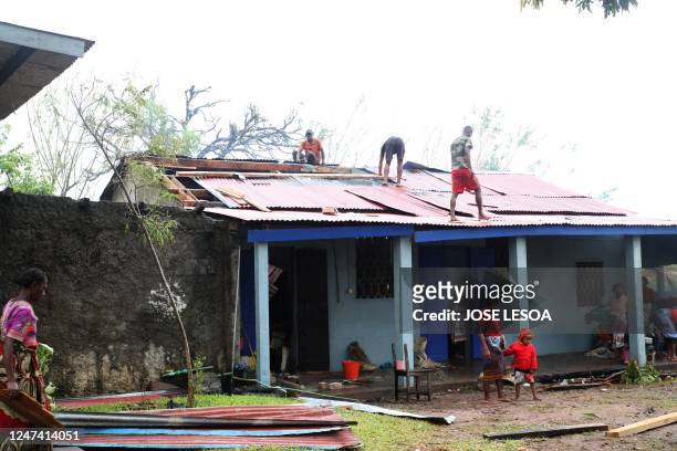 Men repaire the roof of a house in the aftermath of cyclone Freddy in Mananjary on February 23, 2023. - A powerful cyclone was barrelling towards...