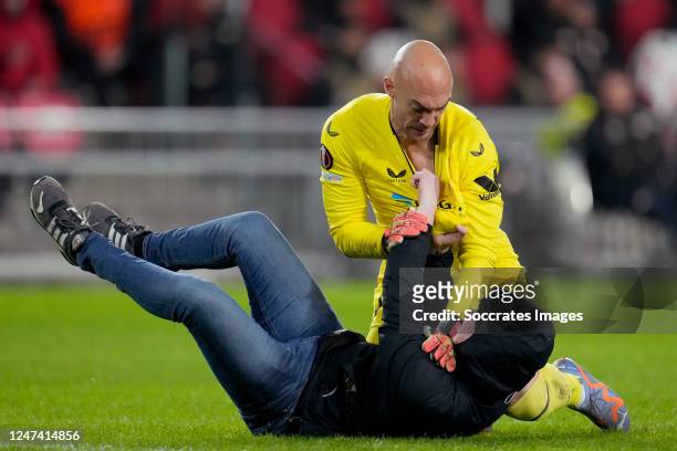 Pitch entrant in combat with Marko Dmitrovic of Sevilla FC during the UEFA Europa League match between PSV v Sevilla at the Philips Stadium on...