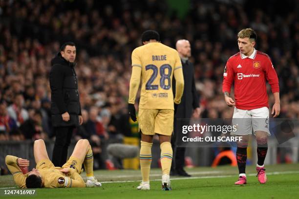 Manchester United's Argentinian defender Lisandro Martinez looks at Barcelona's Polish forward Robert Lewandowski on the floor during the UEFA Europa...