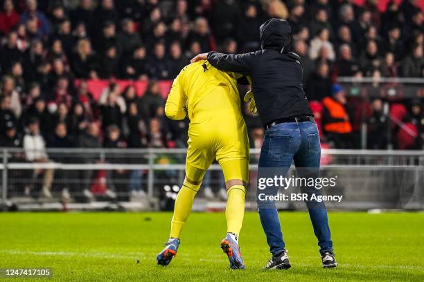 Marko Dmitrovic of Sevilla FC is attacked by a supporter who invaded the pitch during the UEFA Europa League Knockout Round Play-Off Leg Two match...