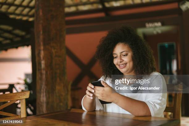 frau mit smartphone am restauranttisch - royalty free stock-fotos und bilder