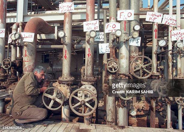 An Iraqi worker checks oil valves at the Dora refinery in Baghdad 26 November. Under the UN oil-for-food accord, Iraq has finally received the first...