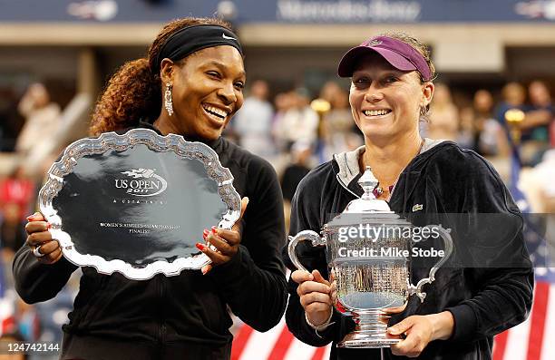 Samantha Stosur of Australia celebrates with the championship trophy alongside Serena Williams of the United States who poses with the second place...