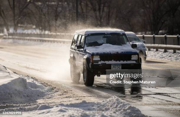 Snow blows from the roof of a vehicle as it drives down Hennepin Avenue on February 23, 2023 in Minneapolis, Minnesota. The winter storm has caused...