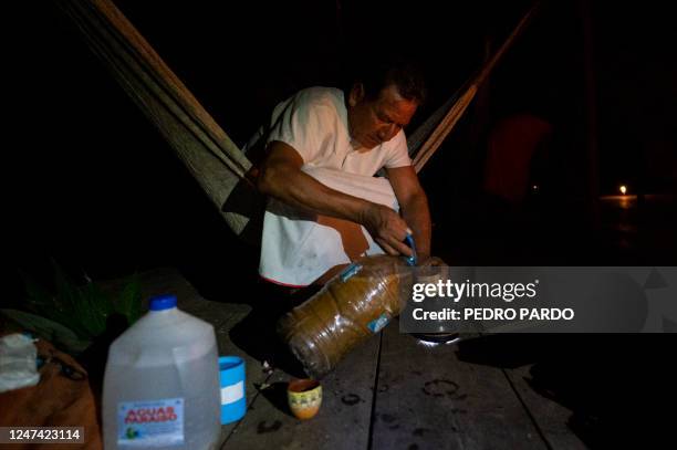 Miguel Payaguaje, healer of the indigenous Siekopai ethnic group , pours Yage during a drinking ceremony in Lagartococha, Mañoco, Amazon region,...