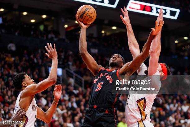 Precious Achiuwa of the Toronto Raptors drives to the net between Trey Murphy III and Larry Nance Jr. #22 of the New Orleans Pelicans during the...