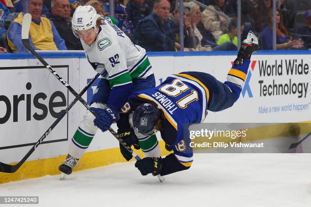 Vasily Podkolzin of the Vancouver Canucks knocks Robert Thomas of the St. Louis Blues to the ice in the second period at Enterprise Center on...