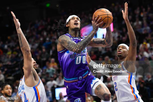 Jordan Clarkson of the Utah Jazz shoots between Kenrich Williams and Shai Gilgeous-Alexander of the Oklahoma City Thunder during the first half of a...