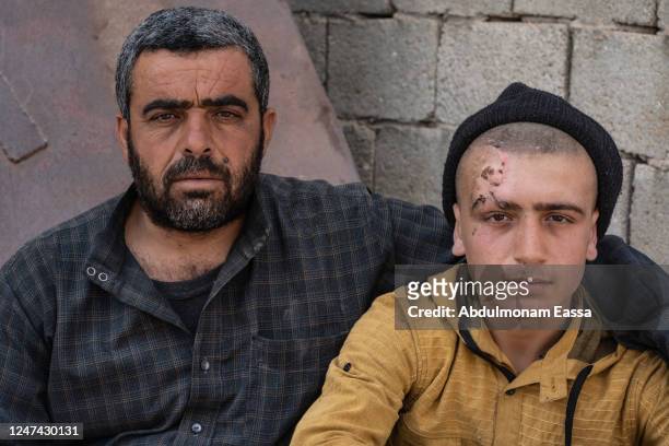 Mohammad Kharofe 14-years-old poses for a photograph with His Father Omar Kharofe 39-years-old near his destroyed home, they survived but according...