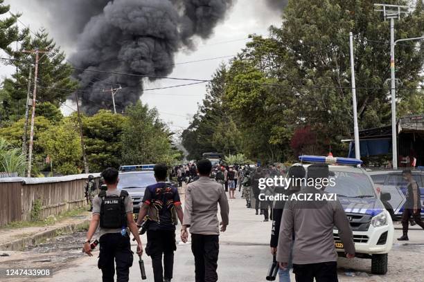 This picture taken on February 23, 2023 shows police officers dispersing people in Wamena. - Indonesia has deployed security forces to Wamena town in...