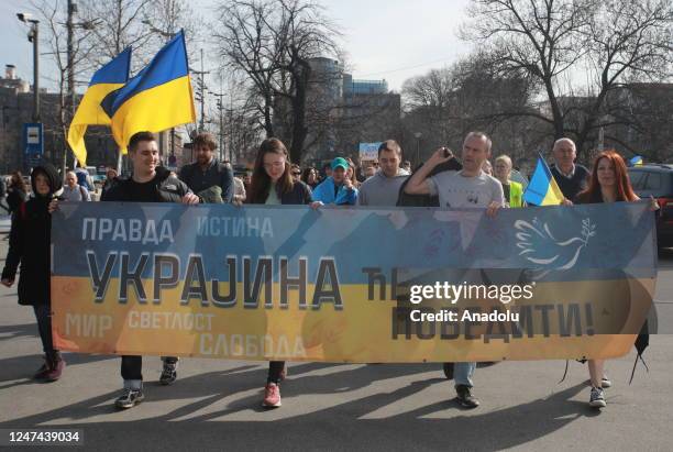 People take part in a demonstration to show solidarity with Ukraine on the first anniversary of the Russia - Ukraine war in Belgrade, Serbia on...