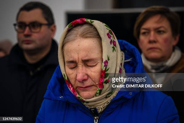 Attendee reacts during a prayer service in St Andrew's Church in Bucha, near Kyiv on February 24 on the first anniversary of the Russian invasion of...