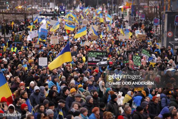 Demonstrators waving flags of Ukraine attend a demonstration in support of Ukraine, on Karl-Marx-Allee in Berlin, on February 24 the first...