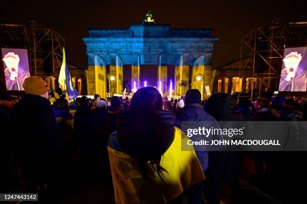 The Brandenburg Gate is illuminated in the colours of Ukraine as protestors attend a rally in Berlin on February 24 marking the first anniversary of...